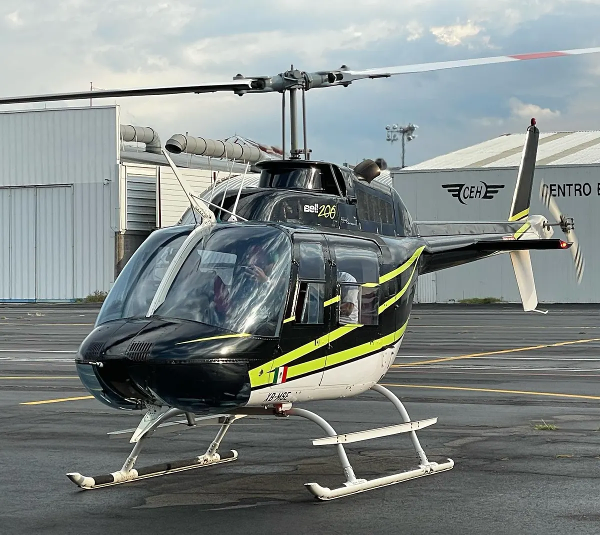 Bell 206 negro con franjas amarillas en la plataforma