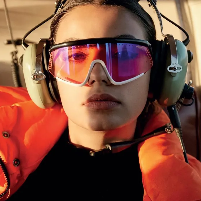 Pasajera con audífonos de aviación y lentes dentro de la cabina